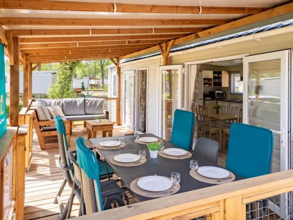 Die geräumige Terrasse der Comfort Lounge ist mit einem Tisch, Stühlen und einem bequemen Loungesofa ausgestattet.