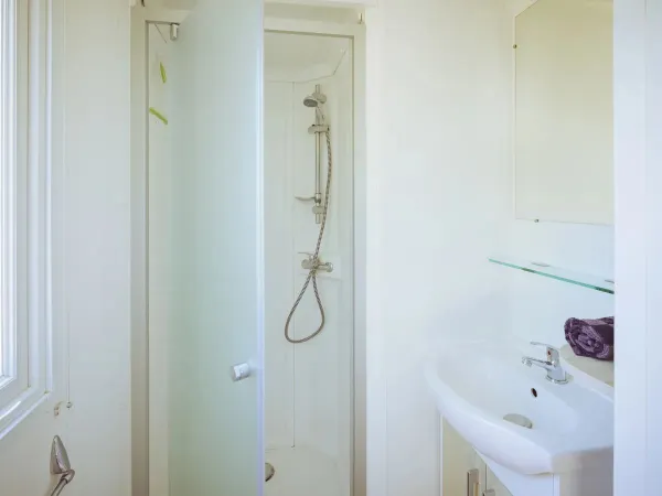 Das Roan Premium Badezimmer mit Duschkabine und Waschbecken mit Unterschrank.