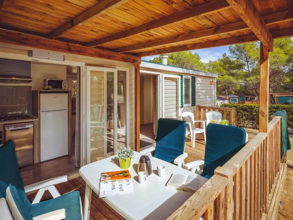 Die geräumige Terrasse des Comfort plus ist mit einem Tisch und mehreren Stühlen ausgestattet.