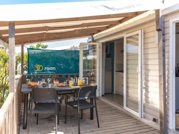 Die Veranda des Roan Premium verfügt über einen Esstisch mit Gartenstühlen.