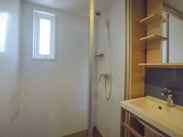 Das Badezimmer der Roan Supreme Plus Lounge verfügt über eine geräumige Duschkabine und ein Waschbecken.