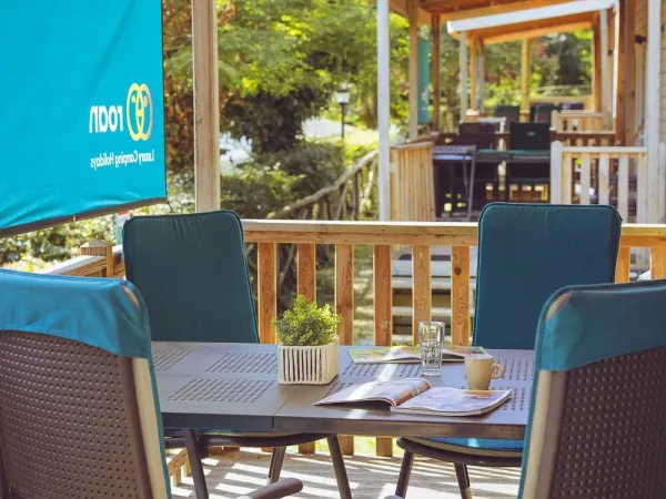 Die Veranda des Roan Premium Compact verfügt über einen Esstisch mit Stühlen.