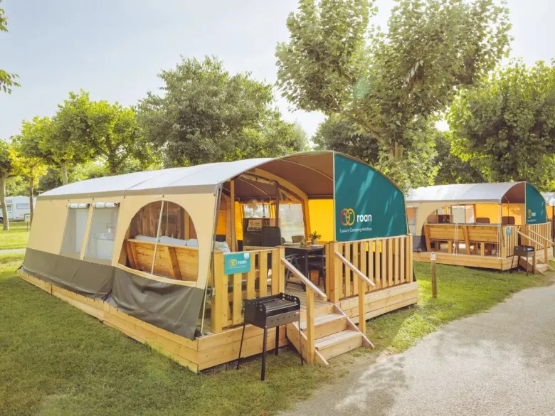 Das Roan Lodgetent Holiday hat eine Veranda mit fester Markise und Grillplatte.