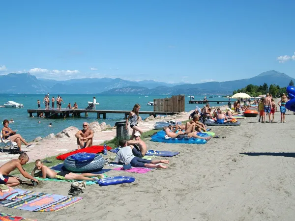 Belebter Strand am Gardasee auf dem Campingplatz Roan Del Garda.