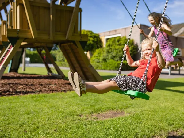 Schaukelnde Kinder auf dem Roan-Campingplatz Marvilla Parks Friese Meren.