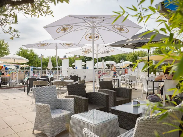 Terrasse mit Liegestühlen und Sonnenschirmen auf dem Roan Camping Butterfly.