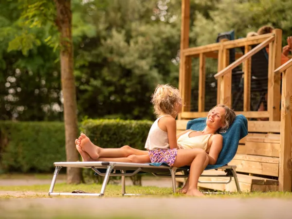 Mutter beim Sonnenbad in der Lounge der Unterkunft.