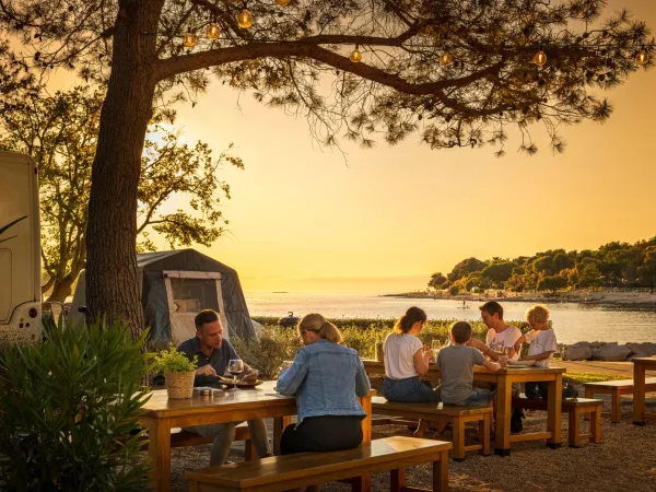 Picknickbänke am Meer auf dem Roan Campingplatz Valkanela.