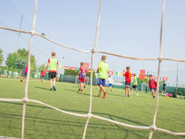 Kinder spielen Fußball auf dem Roan-Campingplatz Marina Di Venetia.