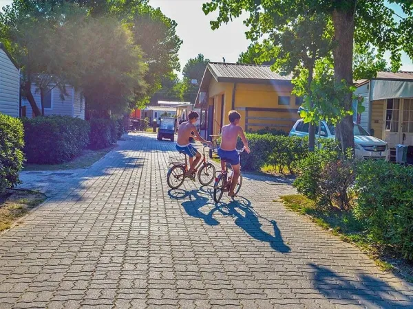 2 Jungen radeln über den Roan Campingplatz Sole Family Camping Village.