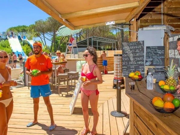 Menschen trinken einen Cocktail auf dem Roan-Campingplatz Le Castellas.