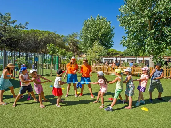 Kinder spielen Tauziehen auf dem Campingplatz Roan Le Castellas.