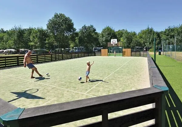 Vater und Sohn spielen Fußball auf dem Fußballplatz des Campingplatzes Domaine de La Brèche in Roan.