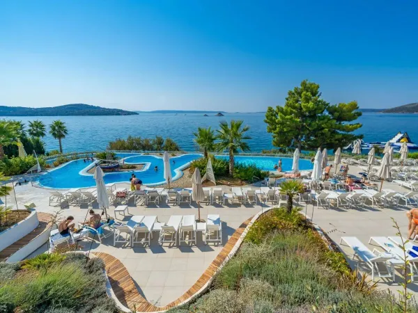 Schwimmbad und Liegestühle mit Blick auf das Meer auf dem Campingplatz Roan Amadria Park Trogir.