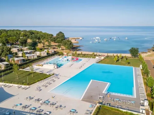 Schwimmbad mit Kinderbecken und Rutschen und Bucht auf dem Campingplatz Roan Park Umag.