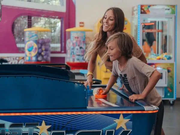Mutter und Sohn an den Spielautomaten des Campingplatzes Les Méditerranées Beach Garden in Roan.