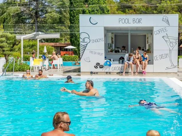 Menschen schwimmen und entspannen sich an der Poolbar auf dem Roan Campingplatz Valkanela.