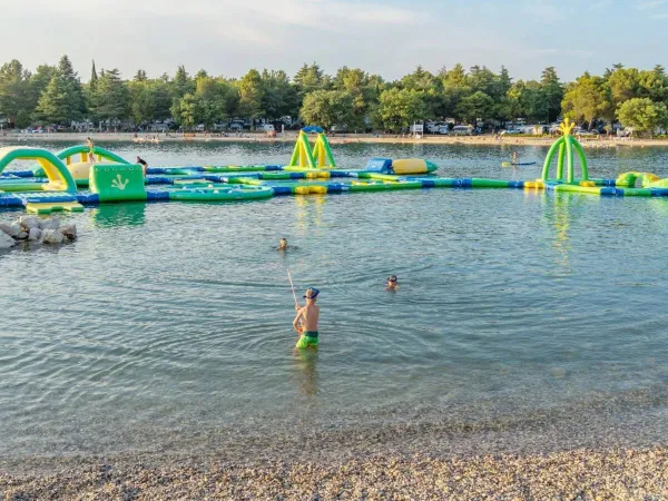 Meer mit Spiel und Hüpfburgen im Wasser auf dem Campingplatz Roan Valkanela.