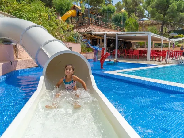 Mädchen auf der Poolrutsche auf dem Roan-Campingplatz Cala Canyelles.