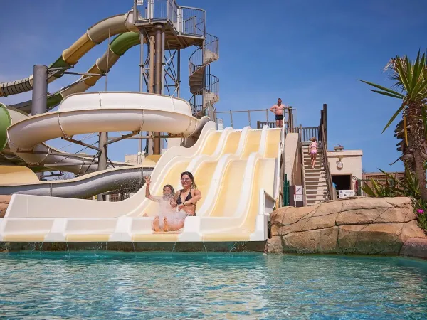 Mädchen rutschen die Rutsche auf dem Roan-Campingplatz Le Petit Mousse hinunter.