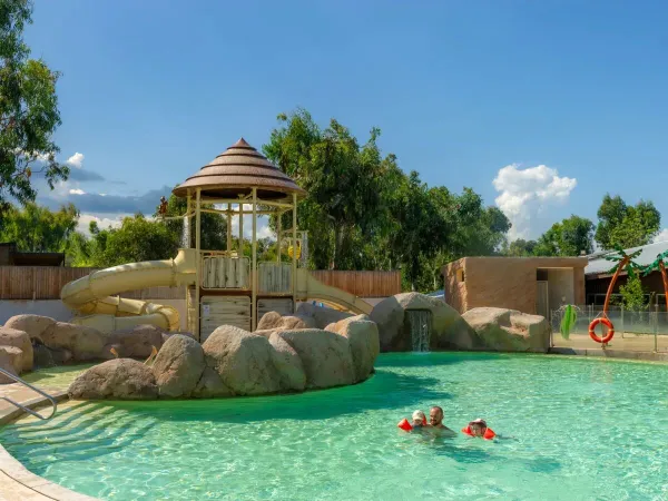 Vater und Kinder schwimmen im Pool des Campingplatzes Arinella Bianca in Roan.
