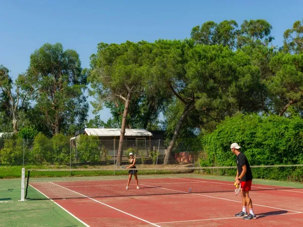 Mann und Frau spielen eine Partie Tennis auf dem Campingplatz Arinella Bianca in Roan.