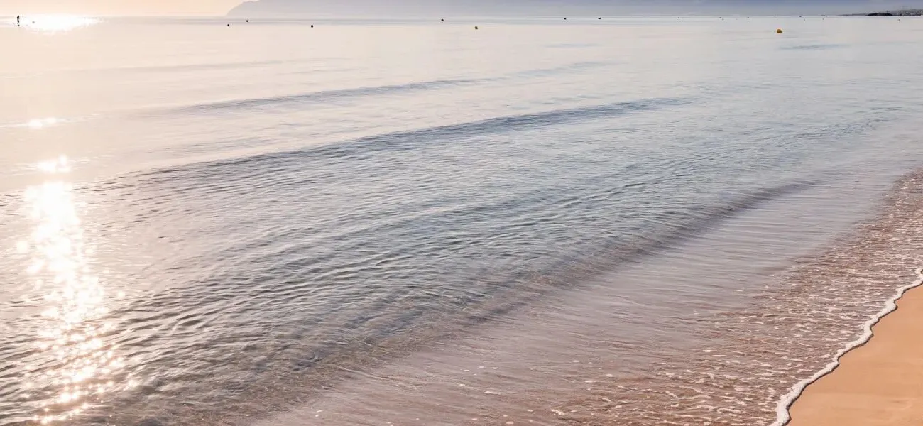 Stimmungsvolles Bild eines Sonnenuntergangs am Strand | Roan Luxury Camping Holidays.